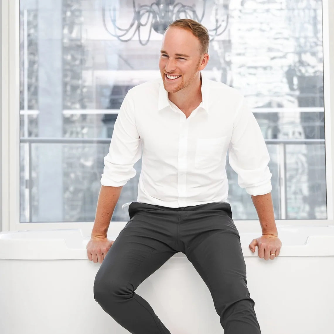 Greg Macdonald, founder of Bathorium, sitting on the edge of a bathtub