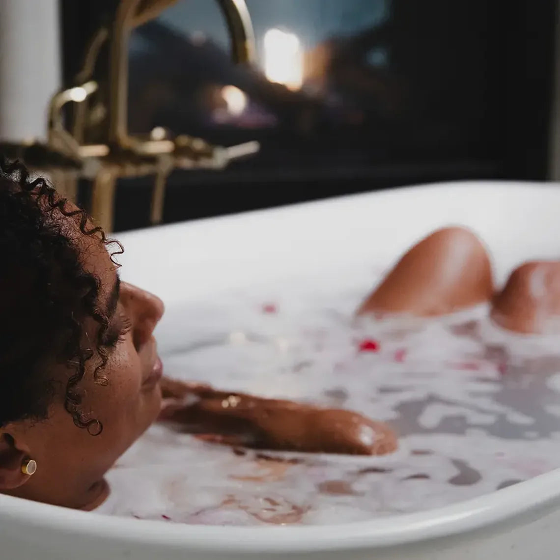 A woman relaxing with her arms on the edge of a Bathorium bath